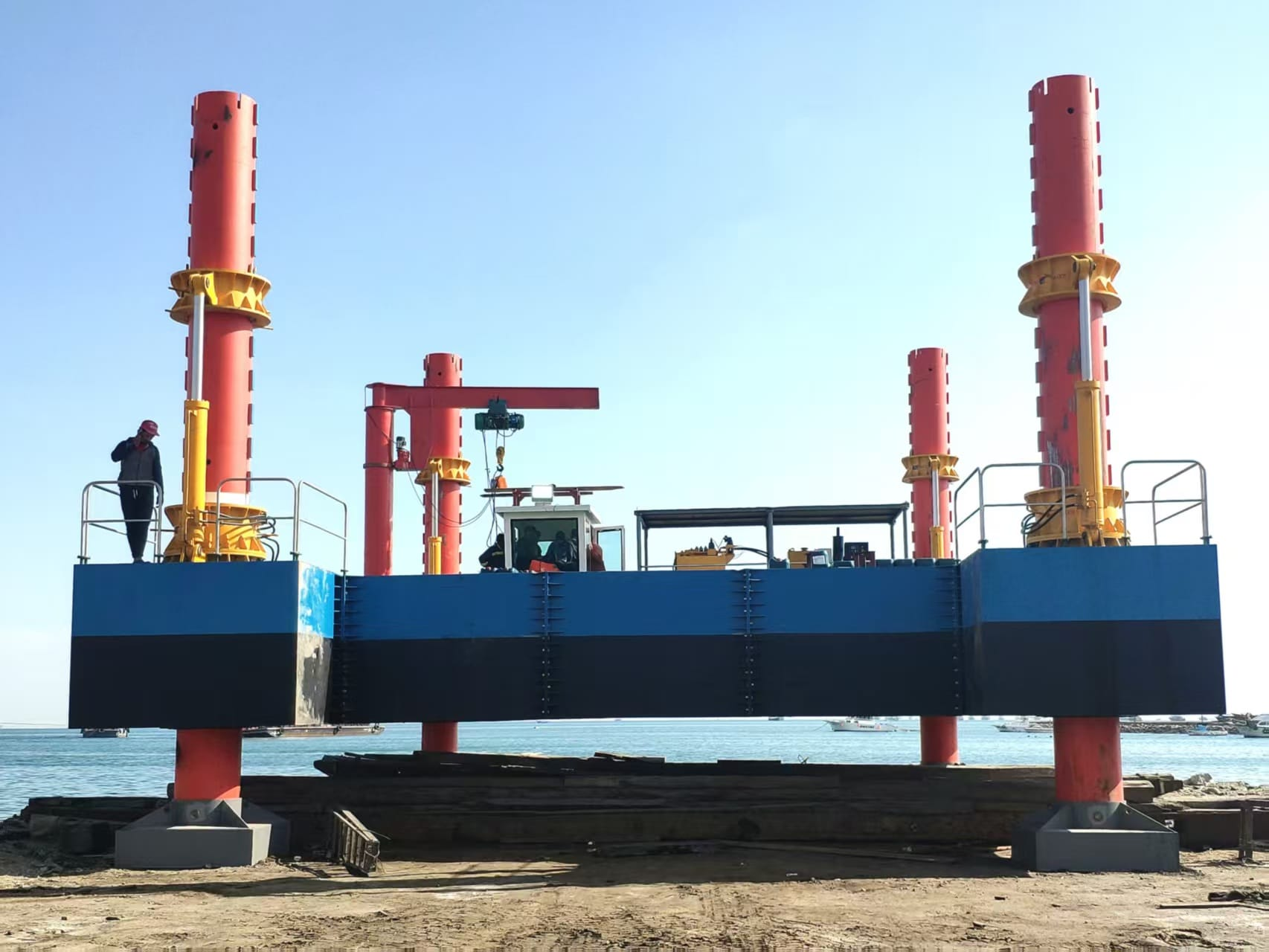 The Group's jack-up marine sand dredger platform with red hydraulic legs, positioned at the shoreline